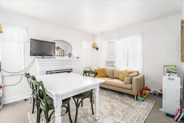 a living room with furniture a flat screen tv and a window