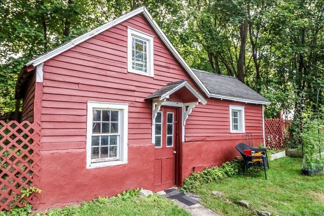a view of a backyard with plants and large tree