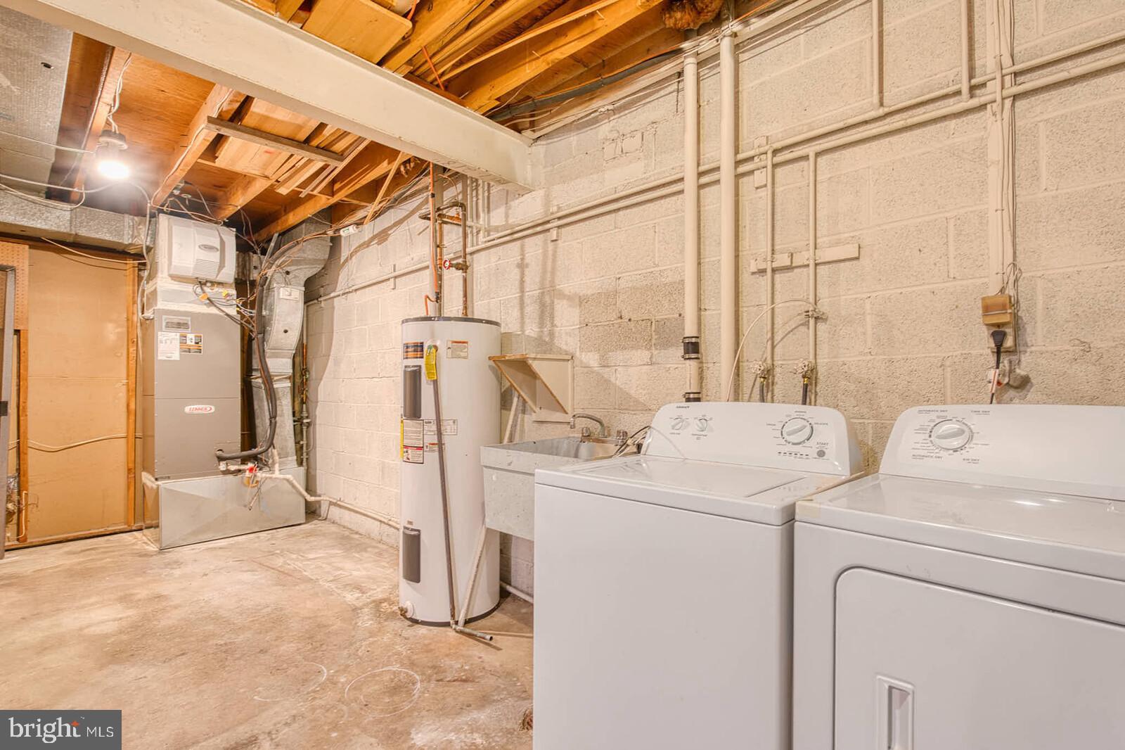 9238 Three Oaks Drive Silver Spring, MD 20901 - Photo 38 of 42 a view of a storage & utility room with dryer and washer