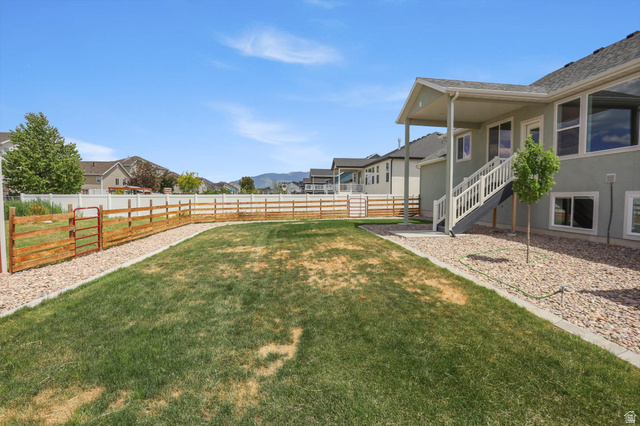 3636 West 910 South Syracuse, UT 84075 - Photo 65 of 70 Expansive backyard featuring a large grass lawn, gravel beds, and a combination of wood and vinyl fencing