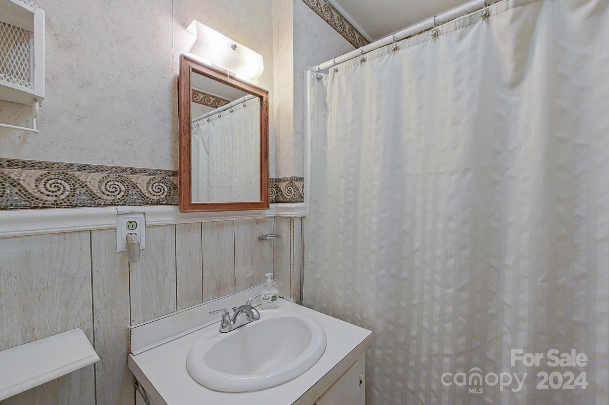 613 Dellinger Road Shelby, NC 28152 - Photo 9 of 19 a bathroom with a sink a mirror and a shower curtain