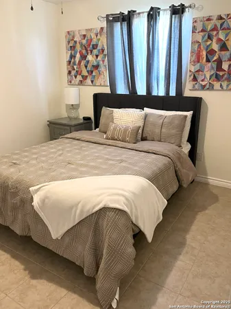 a bedroom with a bed and a painting on the wall
