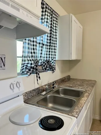 a view of a kitchen sink and cabinets