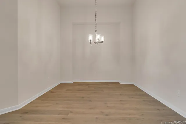 a view of a room with wooden floor and chandelier