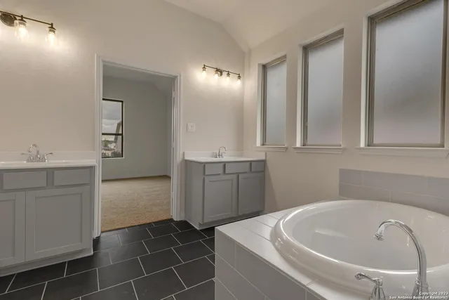 a bathroom with a bathtub sink and mirror
