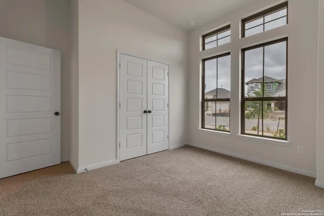 an empty room with windows and closet