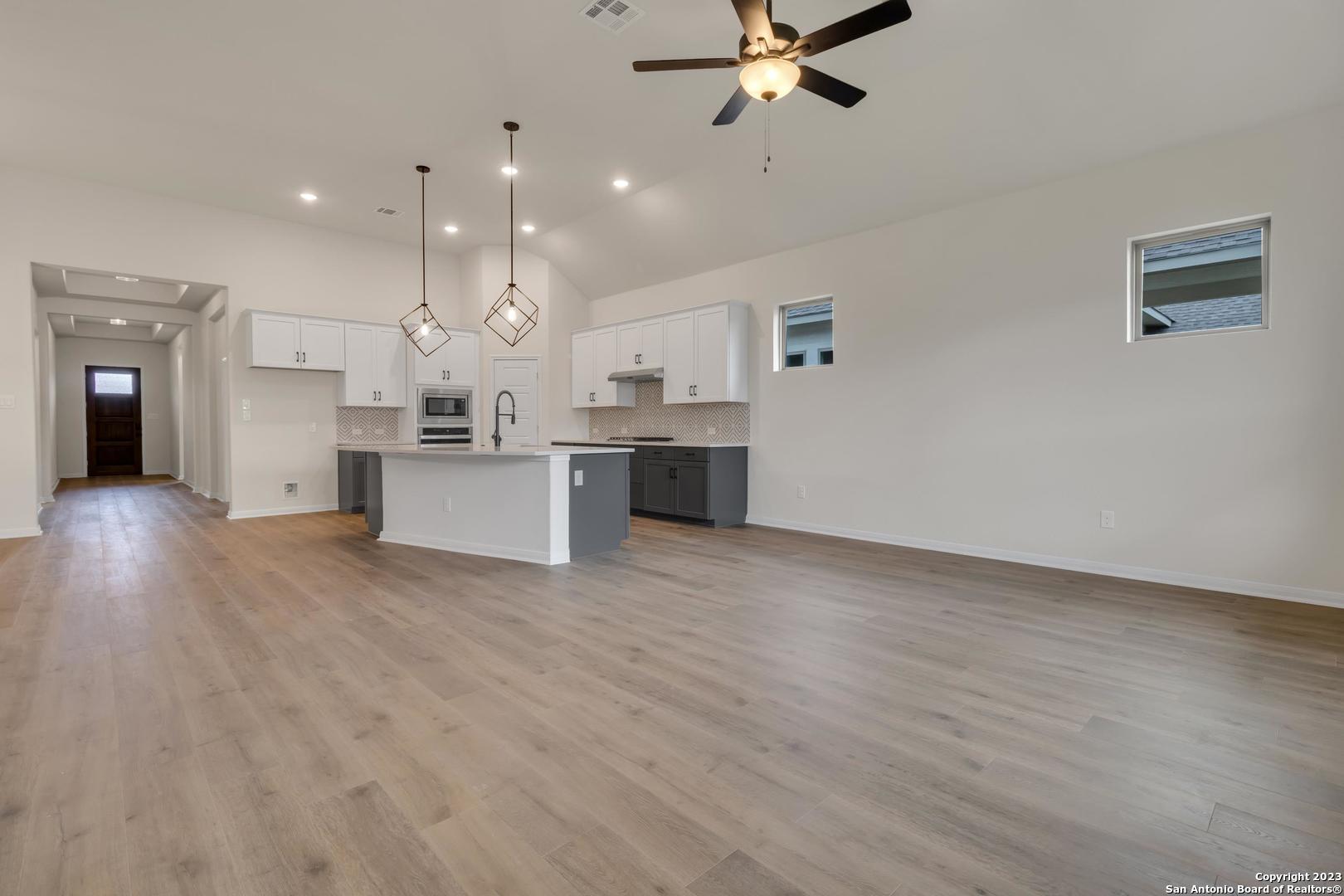 104 Matador Boerne, TX 78006 - Photo 4 of 33 a view of a kitchen with kitchen island a sink wooden floor and a refrigerator