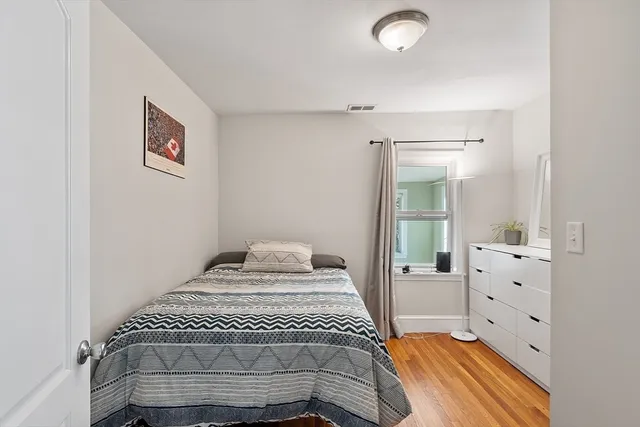 a bedroom with a bed and wooden floor