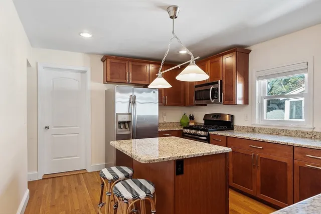 a kitchen with stainless steel appliances granite countertop a sink a stove and refrigerator