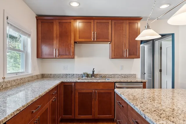 a kitchen with granite countertop a sink and a wooden cabinets