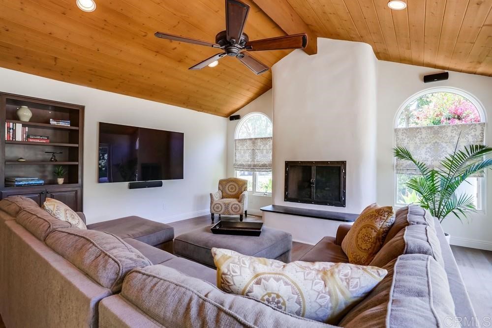 1283 Rancho Encinitas Drive Encinitas, CA 92024 - Photo 11 of 27 a living room with furniture a flat screen tv and a fireplace
