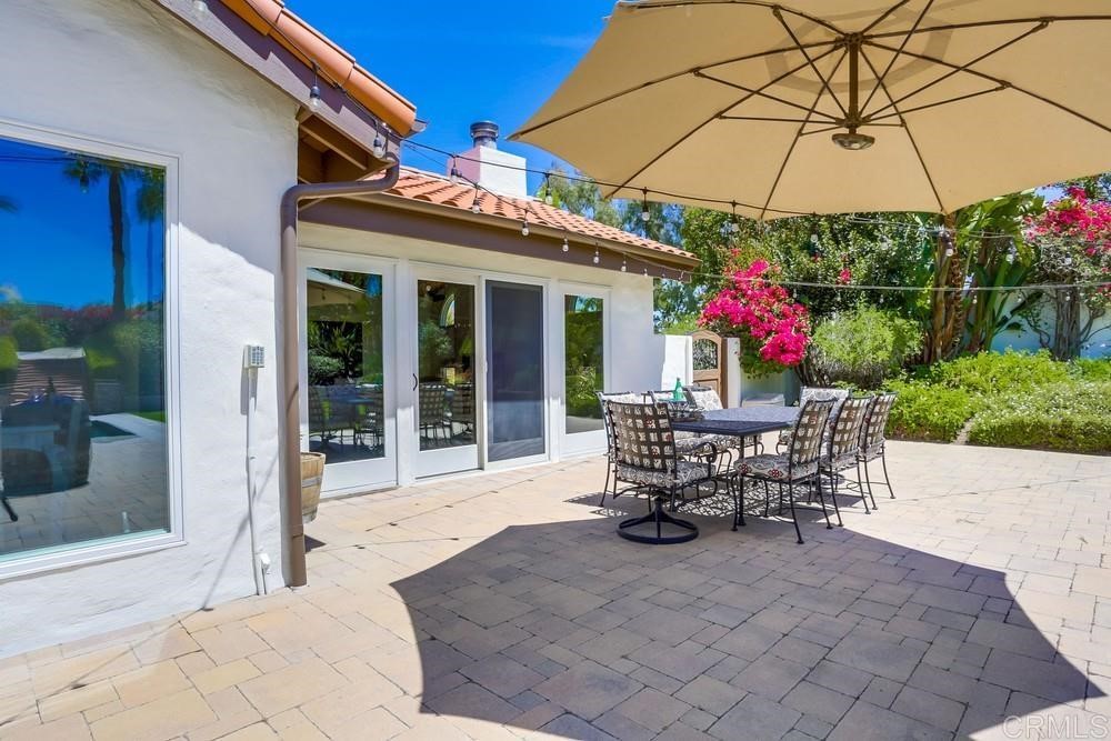 1283 Rancho Encinitas Drive Encinitas, CA 92024 - Photo 20 of 27 a view of a patio with a table and chairs under an umbrella