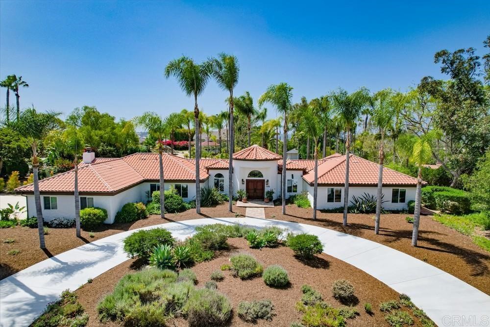 1283 Rancho Encinitas Drive Encinitas, CA 92024 - Photo 4 of 27 a view of a patio with couches and table and chairs under an umbrella