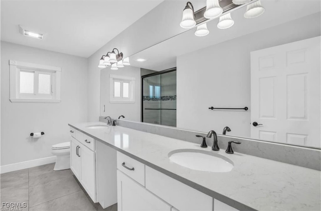 3644 Putter Point Lane Fort Myers, FL 33919 - Photo 28 of 50 a bathroom with a granite countertop double vanity sink a mirror and a bathtub