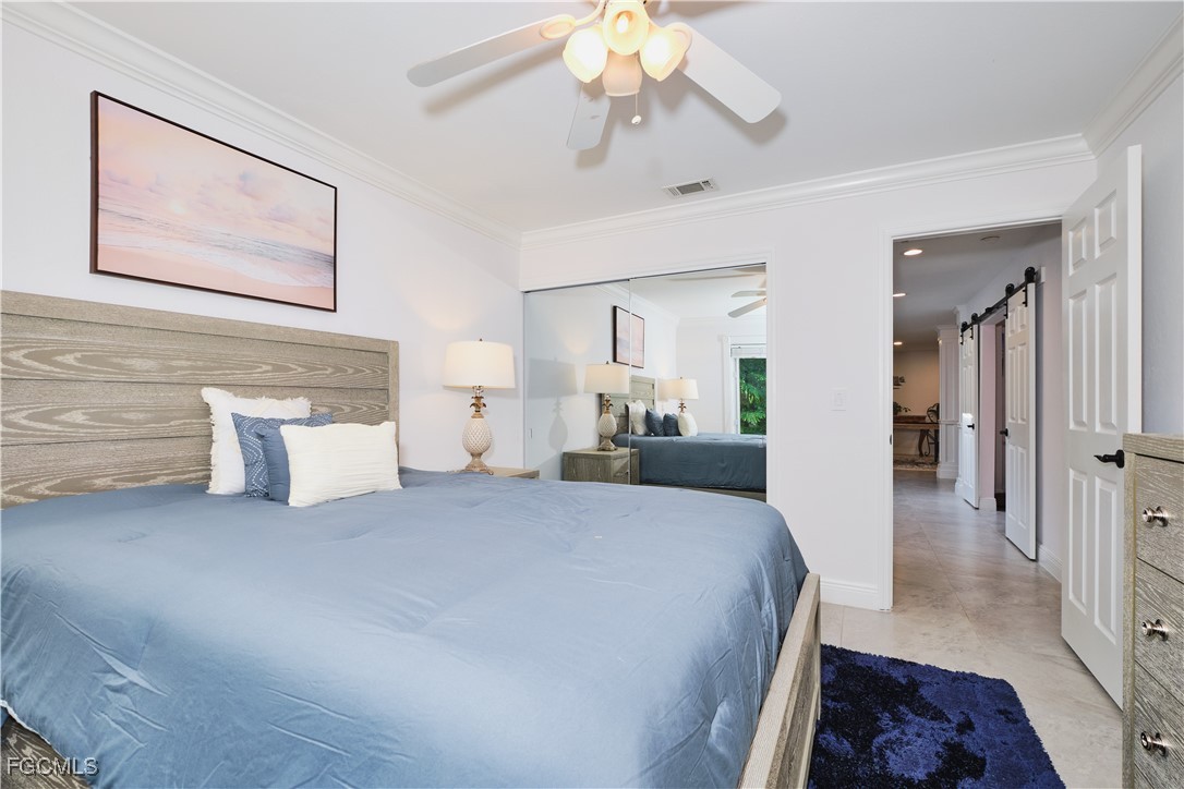 3644 Putter Point Lane Fort Myers, FL 33919 - Photo 33 of 50 a spacious bedroom with a bed and a chandelier