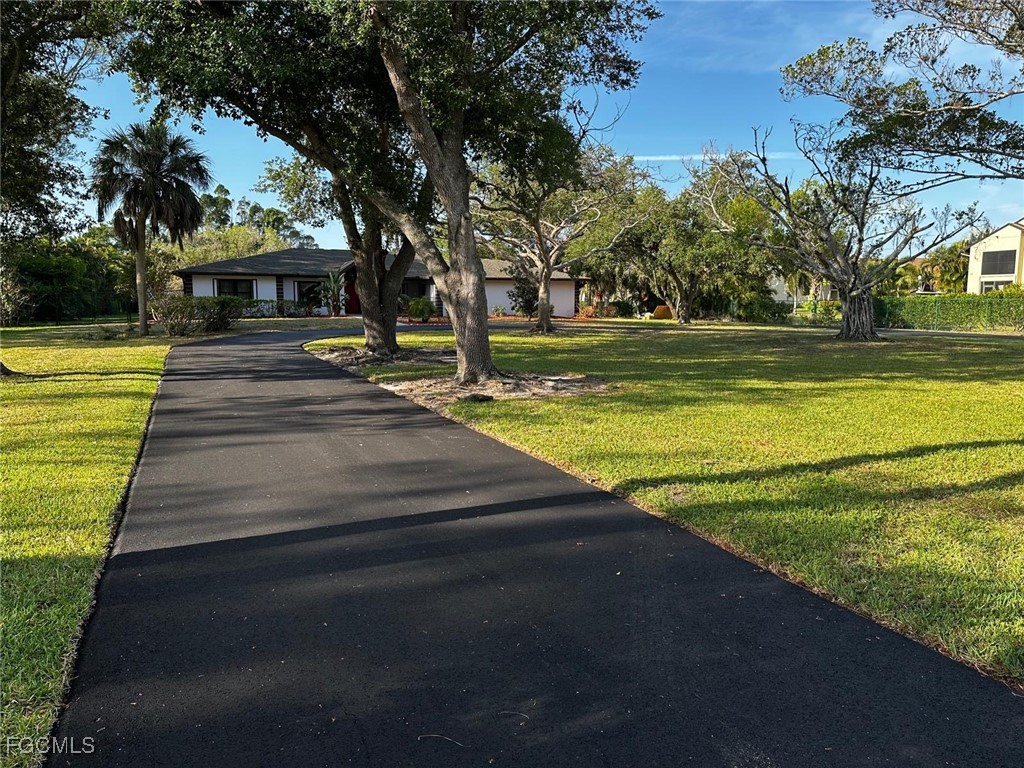 3644 Putter Point Lane Fort Myers, FL 33919 - Photo 5 of 50 a view of yard with swimming pool and trees in the background