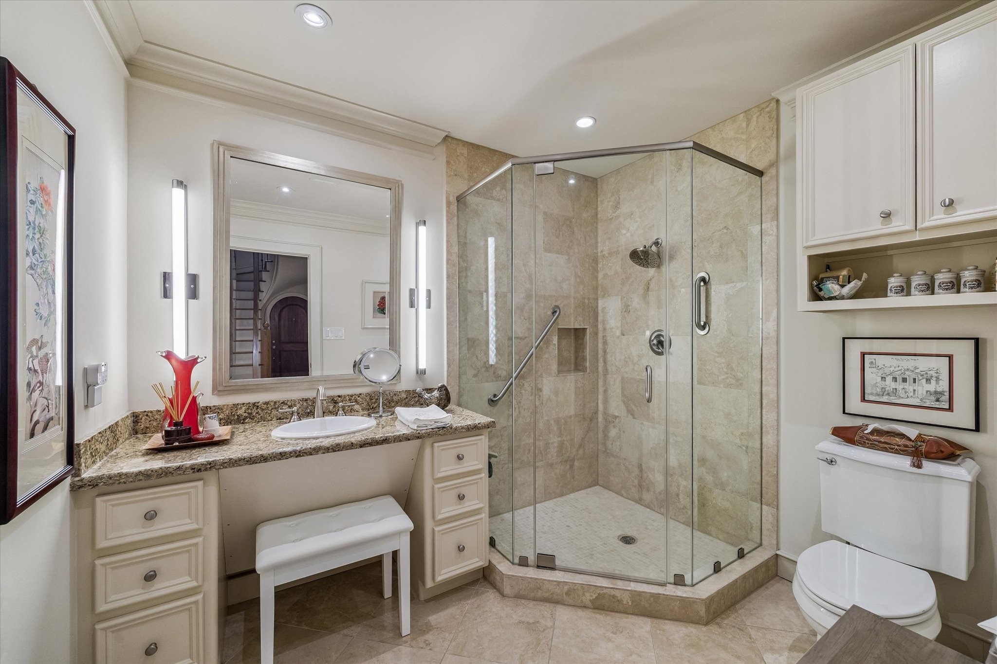 2415 West Main Street Houston, TX 77098 - Photo 18 of 48 Guest Bathroom… First floor bath with travertine floors and walk in shower, granite countertop, elegant vanity lighting, and custom built ins enhanced by refined crown molding.