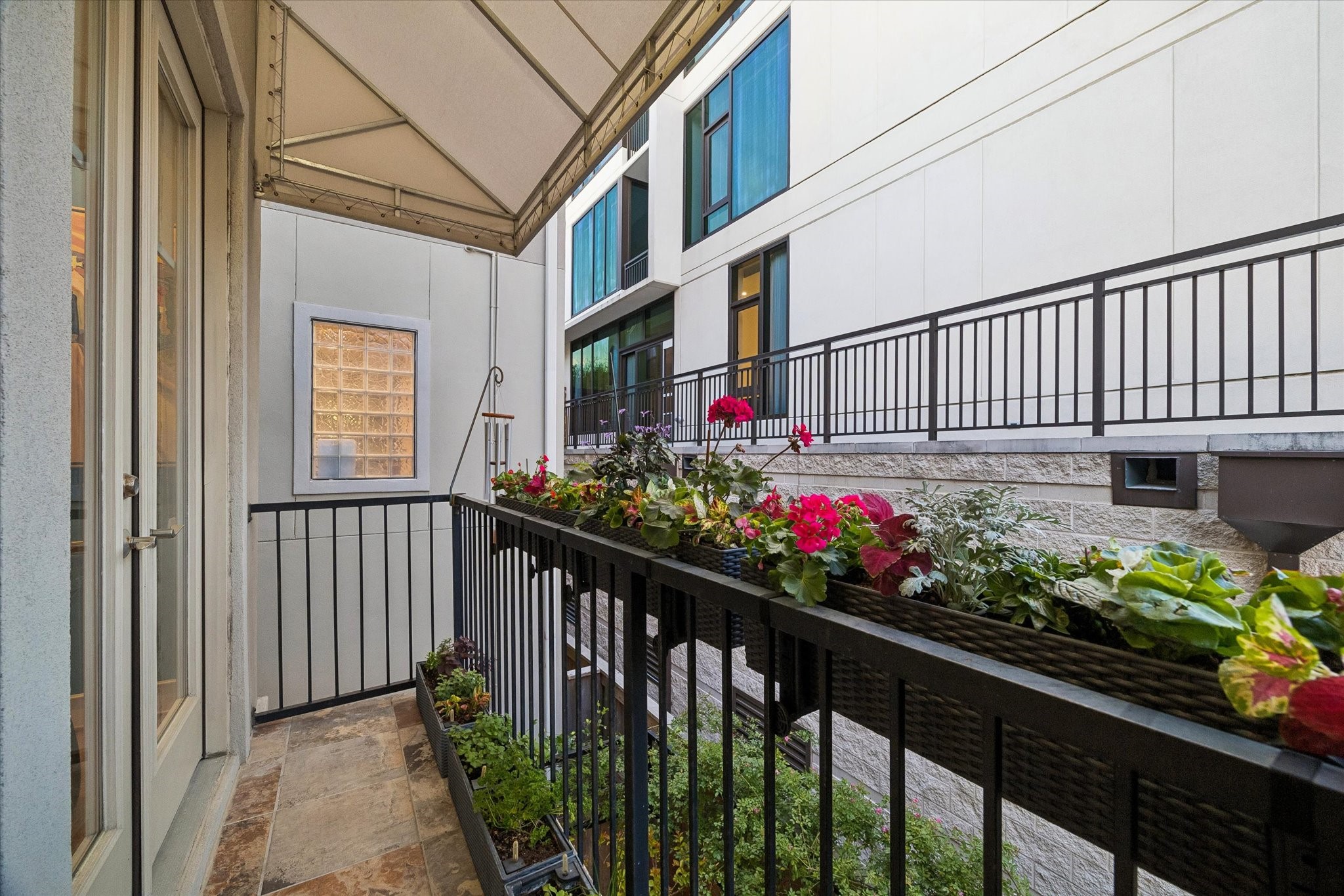 2415 West Main Street Houston, TX 77098 - Photo 24 of 48 Located directly off the family/breakfast room, this inviting balcony features a curated herb garden and a custom-designed awning, providing a shaded, serene space perfect for cooking inspiration or quiet outdoor moments.