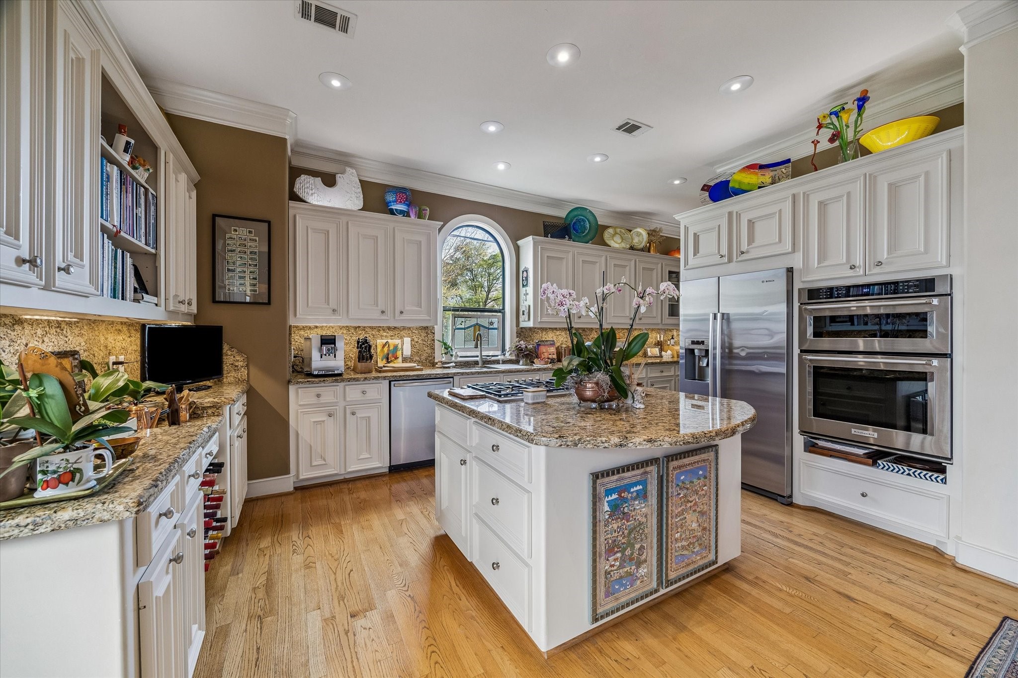 2415 West Main Street Houston, TX 77098 - Photo 26 of 48 The kitchen features rich hardwoods, detailed millwork, & granite surfaces, complemented by a Thermador 5-burner cooktop with downdraft. A wine rack & layered cabinet lighting add warm sophistication.