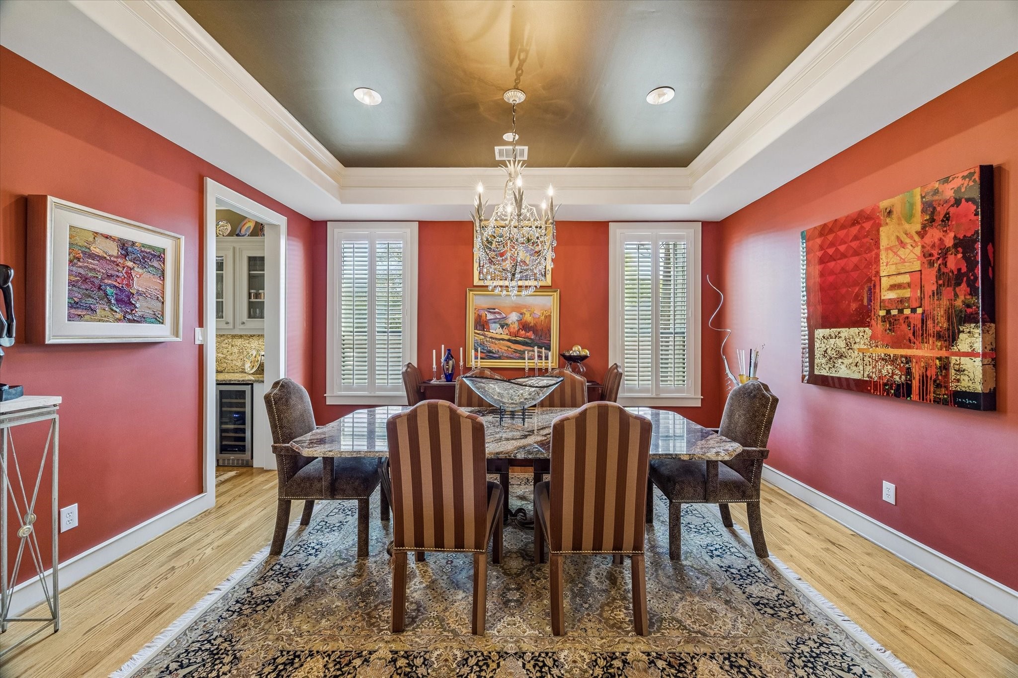 2415 West Main Street Houston, TX 77098 - Photo 3 of 48 Formal Dining Room... An elegant space with rich hardwoods, designer paint, plantation shutters, crown molding, & striking chandelier, with seamless access to the butler’s pantry for refined hosting.