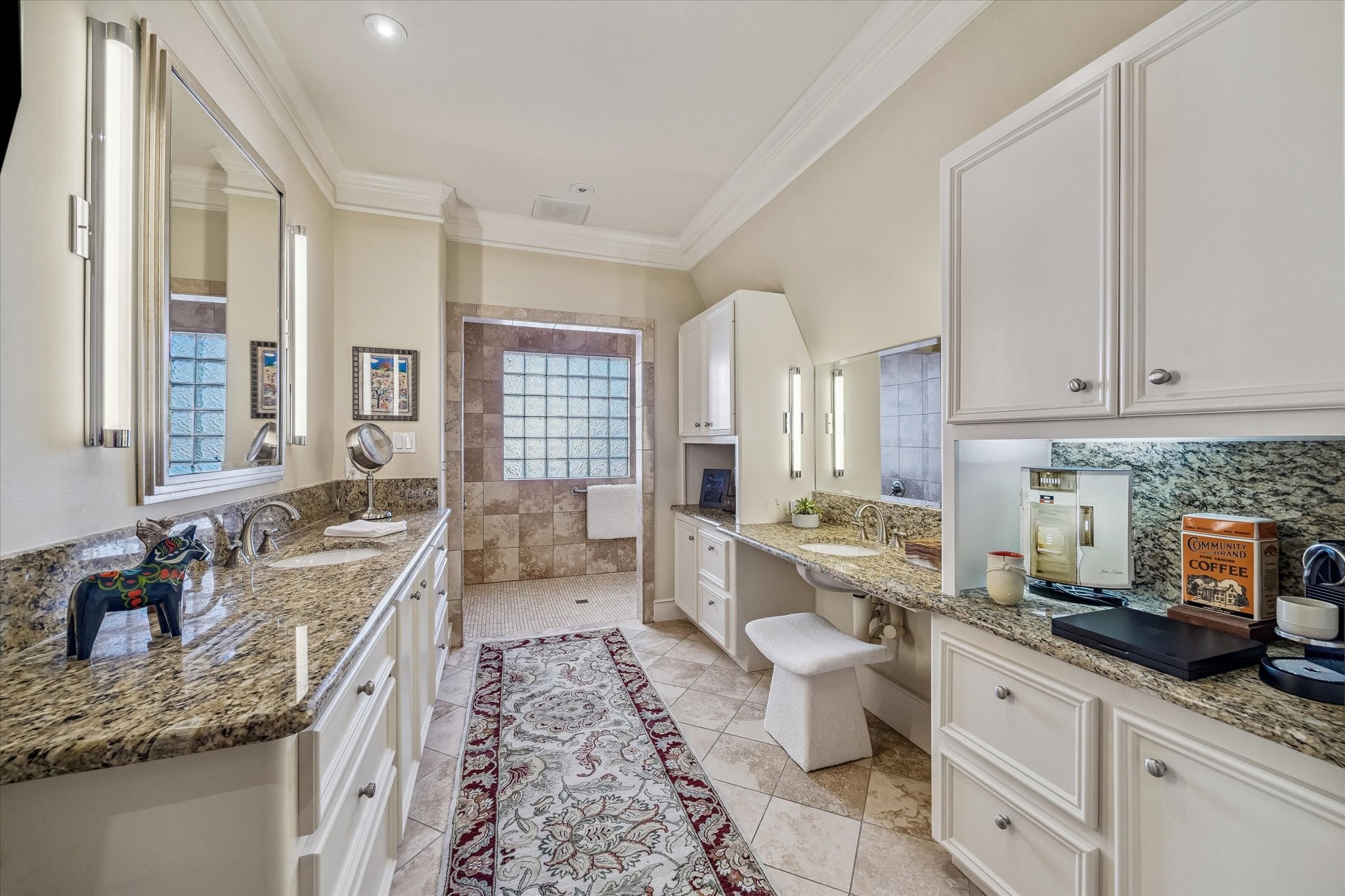 2415 West Main Street Houston, TX 77098 - Photo 34 of 48 Primary Bath… Timeless luxury with warm travertine floors, polished granite counters, dual Kohler sinks, and an illuminated vanity that elevates both style and everyday comfort.