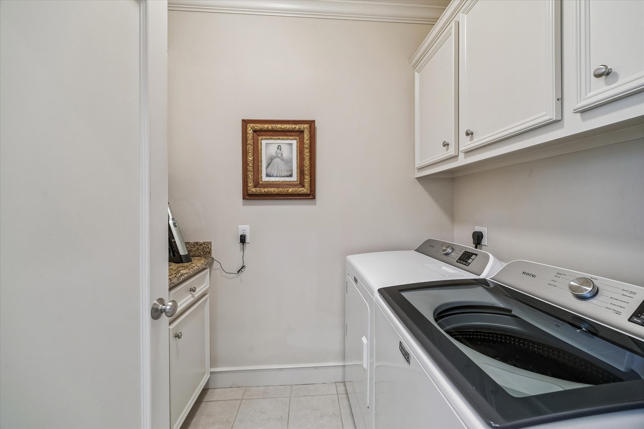 2415 West Main Street Houston, TX 77098 - Photo 39 of 48 The laundry room includes durable tile flooring, a full-size Maytag washer and electric dryer, which are included, and the added functionality of a floor drain—combining practicality with everyday ease.