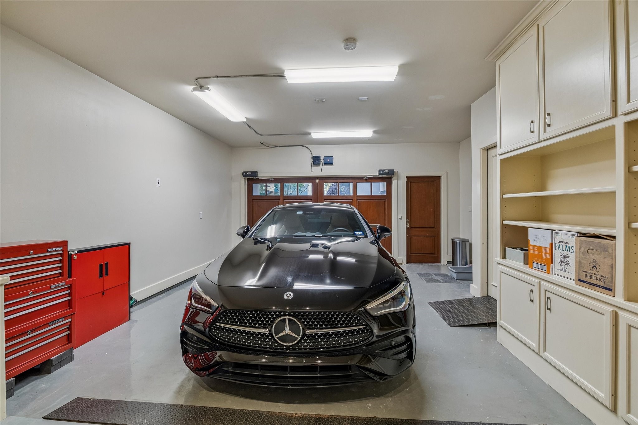 2415 West Main Street Houston, TX 77098 - Photo 40 of 48 Climate controlled garage with painted floors, tailored built ins, and elegant carriage style doors with remote access—offering year round protection and a highly functional, polished space.