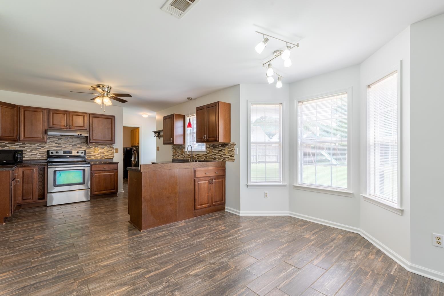 251 Cross Point Cove Collierville, TN 38017 - Photo 11 of 29 a view of a kitchen with kitchen island a large counter top space a sink stainless steel appliances and cabinets