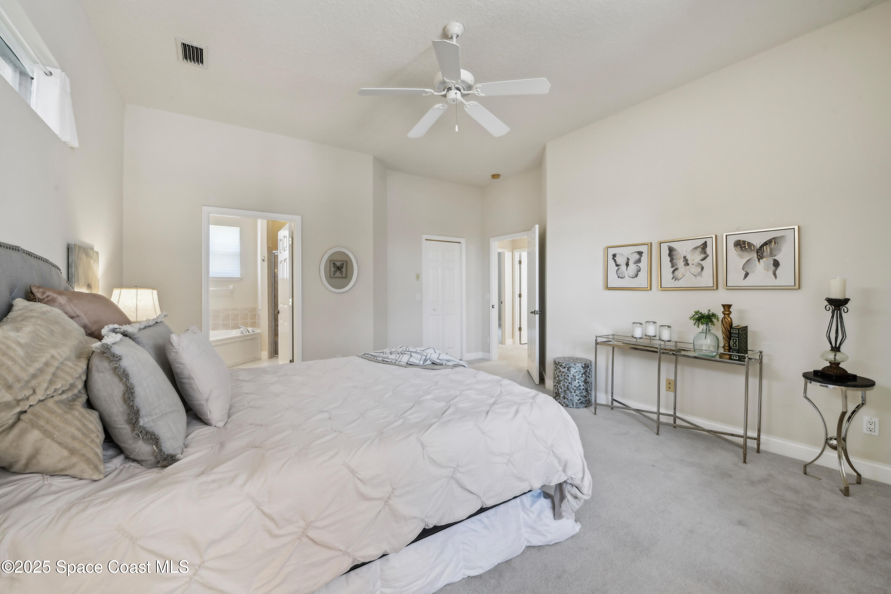 4040 Alamanda Key Drive Melbourne, FL 32901 - Photo 16 of 46 a spacious bedroom with a bed and a chandelier