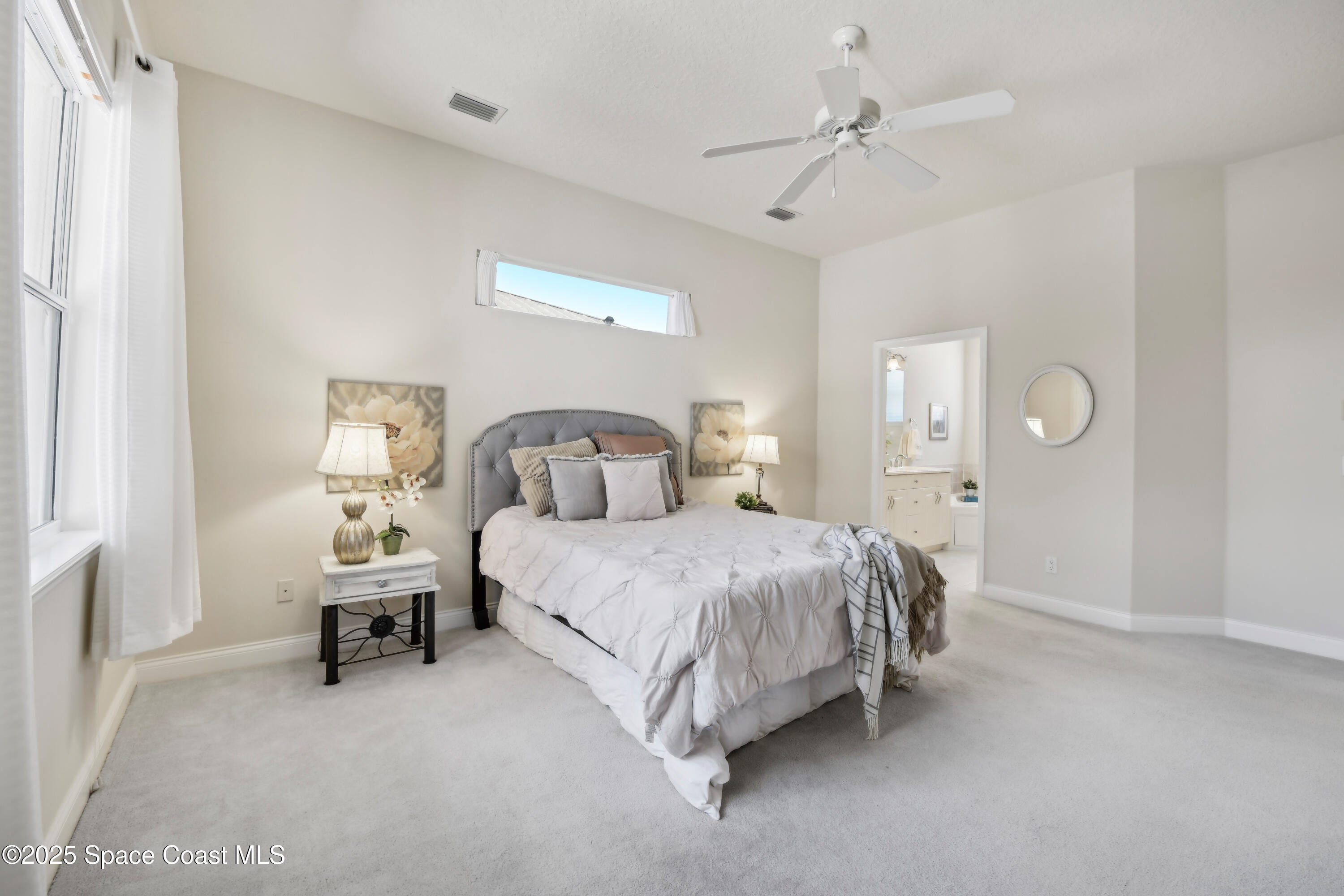 4040 Alamanda Key Drive Melbourne, FL 32901 - Photo 18 of 46 a bedroom with a bed and a chandelier