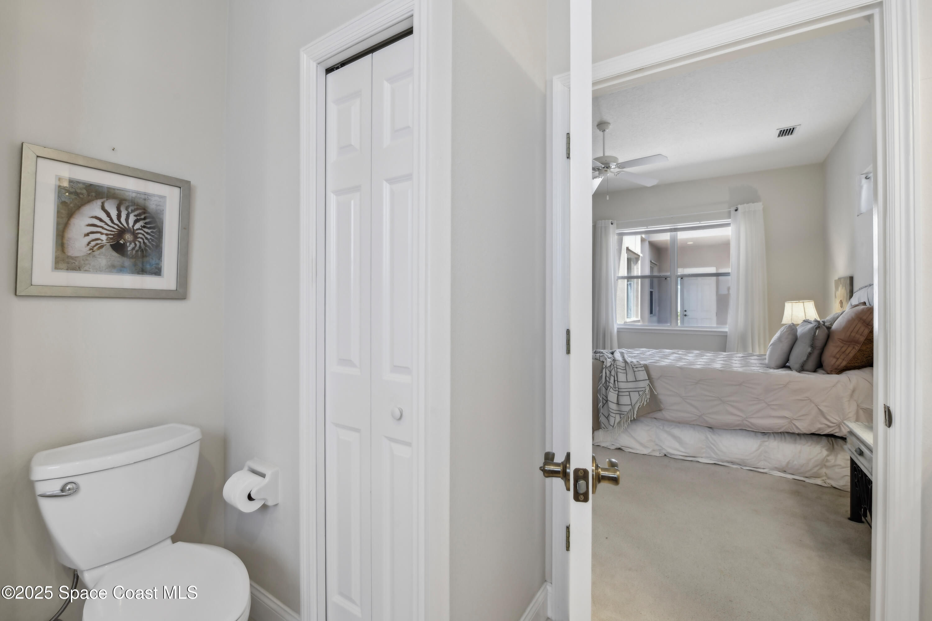 4040 Alamanda Key Drive Melbourne, FL 32901 - Photo 21 of 46 a bathroom with a toilet and a painting on the wall