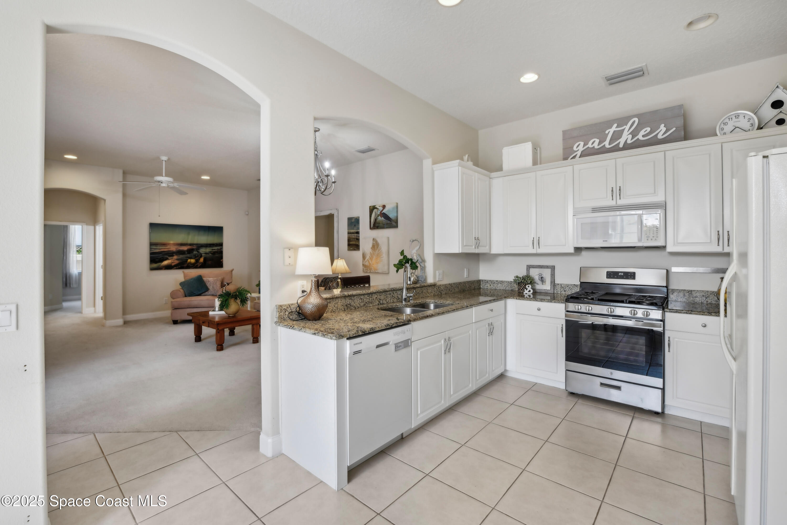 4040 Alamanda Key Drive Melbourne, FL 32901 - Photo 7 of 46 a kitchen with stainless steel appliances granite countertop a stove and white cabinets