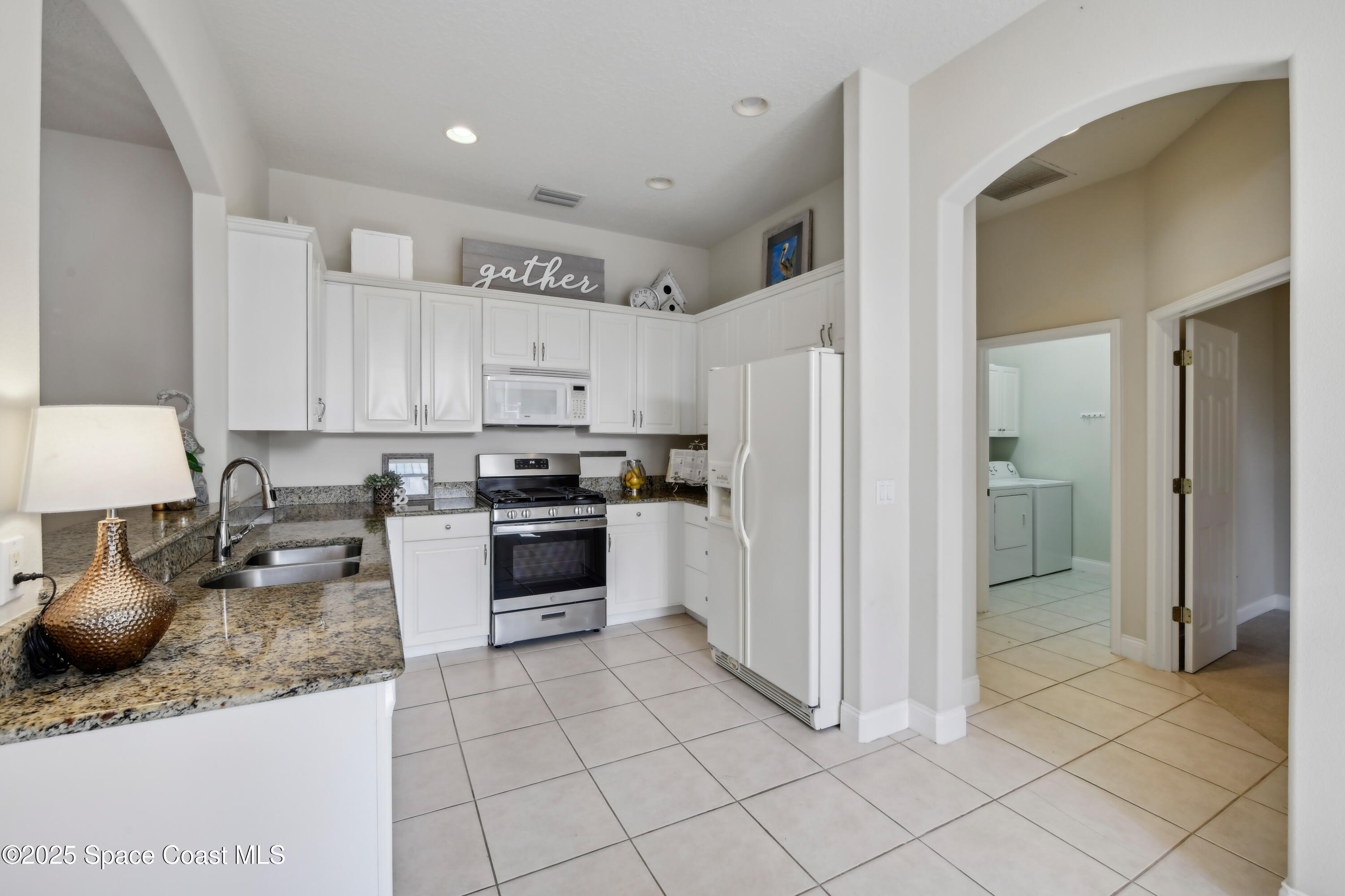 4040 Alamanda Key Drive Melbourne, FL 32901 - Photo 9 of 46 a kitchen with granite countertop a refrigerator and a stove top oven