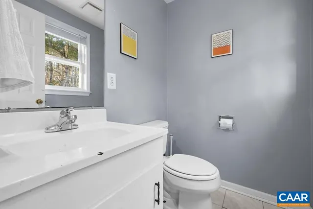 a bathroom with a sink a toilet and a window