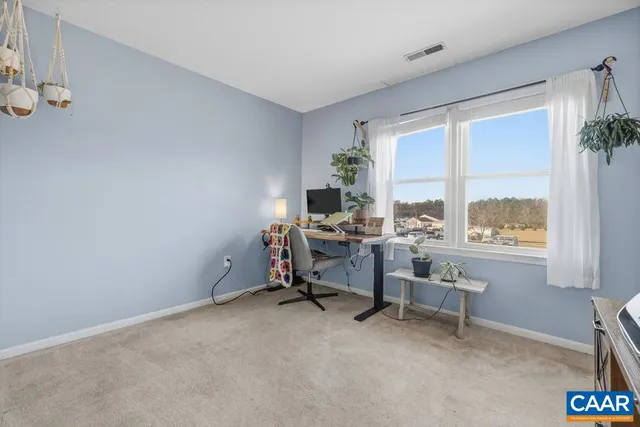 a view of a workspace with furniture and a window