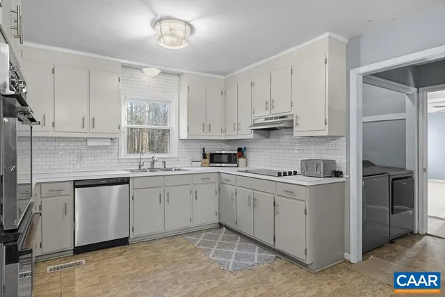 a kitchen with stainless steel appliances granite countertop a sink and cabinets