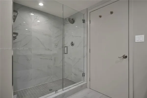 a bathroom with a shower sink vanity mirror and toilet