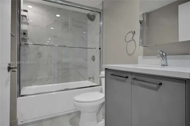 a bathroom with a shower sink vanity mirror and toilet