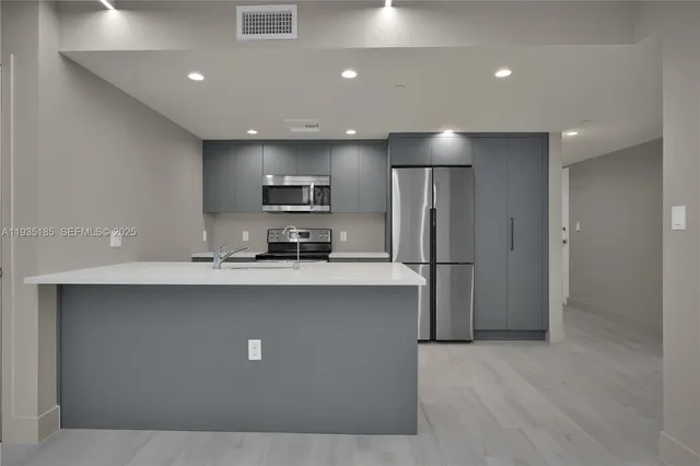 a kitchen with stainless steel appliances a refrigerator and a sink