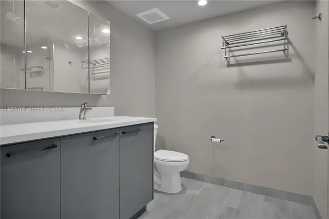 a bathroom with a sink a toilet and a mirror