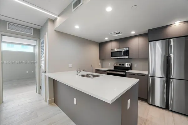 a kitchen with stainless steel appliances granite countertop a sink and a stove