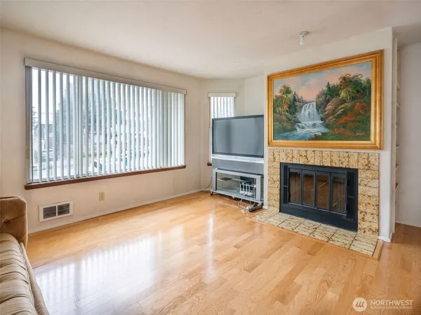 a view of an empty room with a fireplace and a window