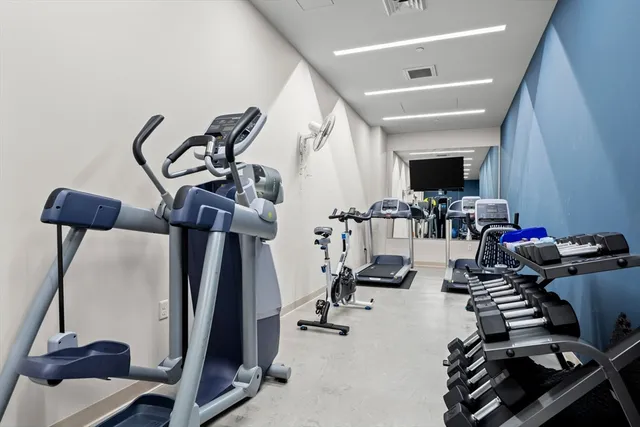 a view of a living room with a flat screen tv and gym equipment