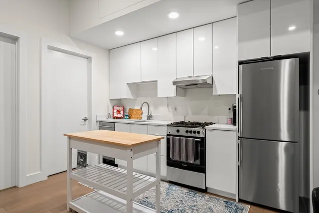 a kitchen with a refrigerator and a stove top oven