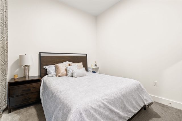 a large bed sitting in a bedroom next to a window