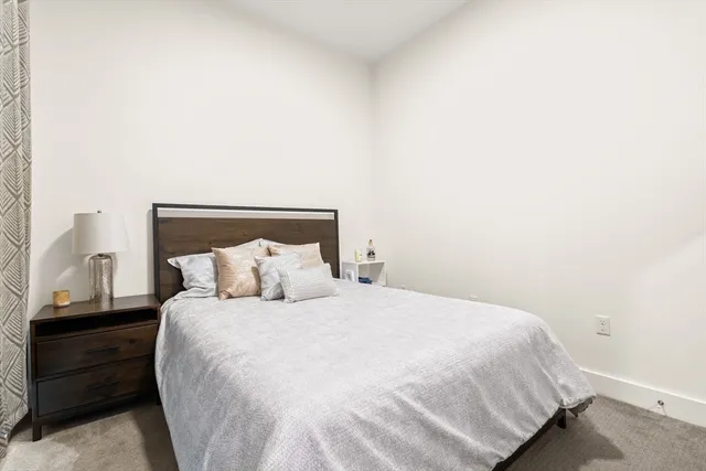 a large bed sitting in a bedroom next to a window