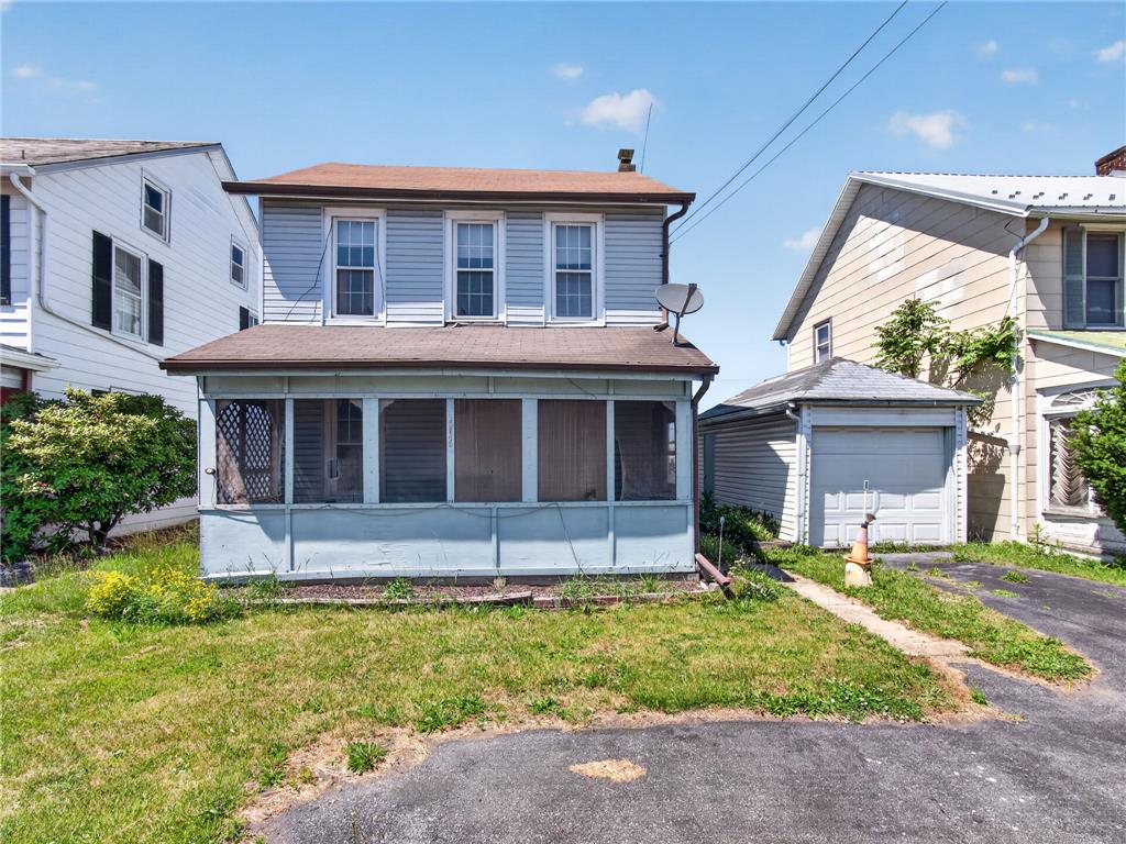 A classic facade with a welcoming screened porch and convenient garage access.