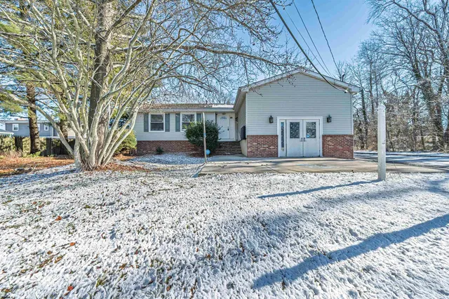 a view of a house with a yard covered in snow