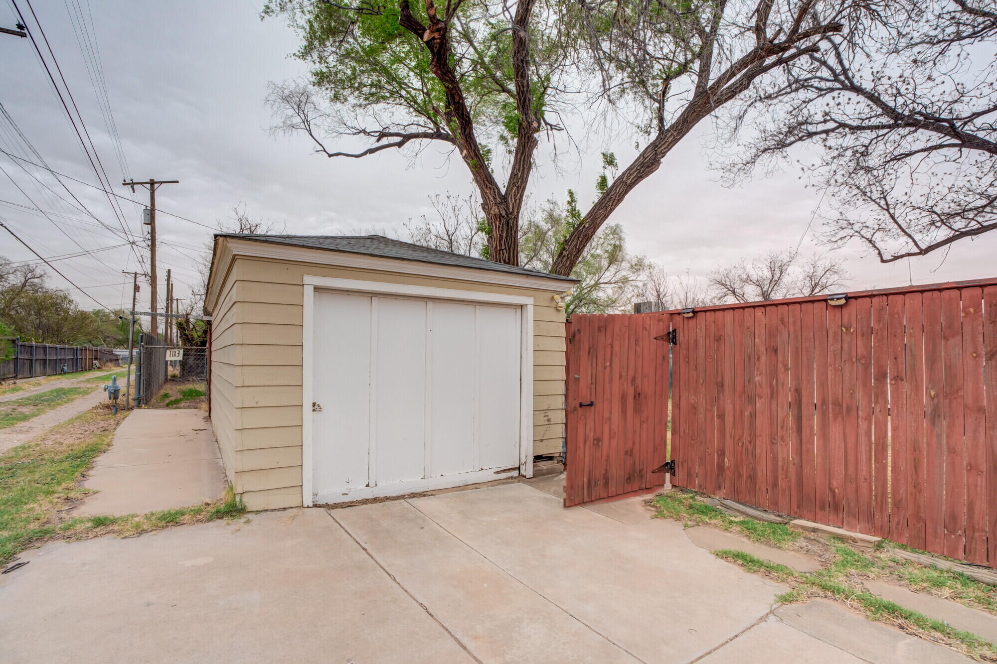 2701 36th Street Lubbock, TX 79413 - Photo 23 of 23 a view of a house with a large tree and wooden fence