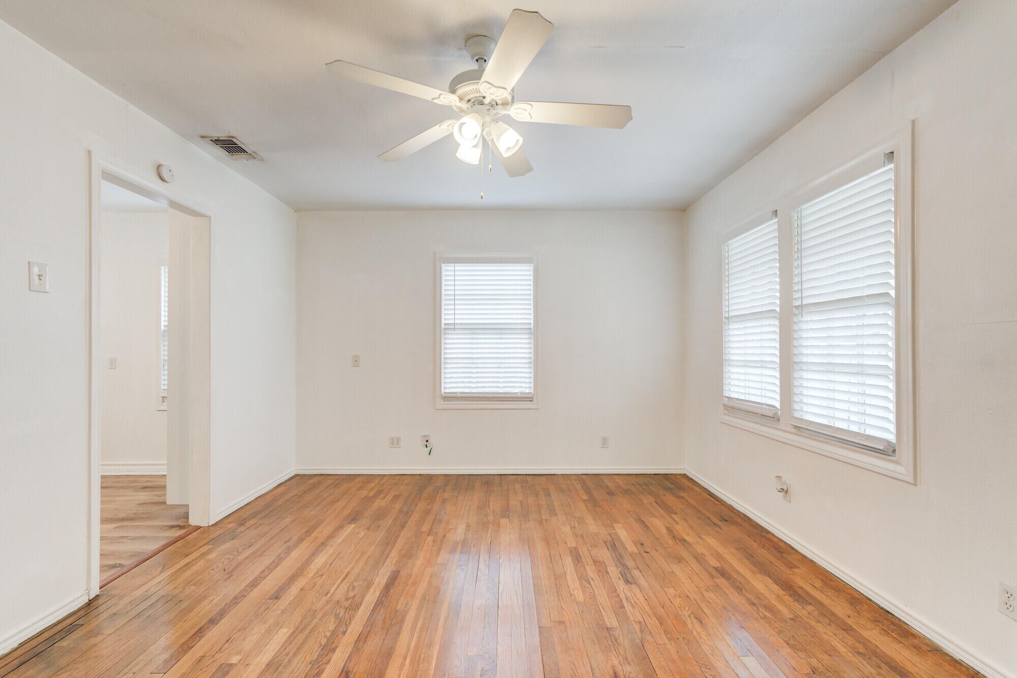 2701 36th Street Lubbock, TX 79413 - Photo 5 of 23 wooden floor in an empty room with a window